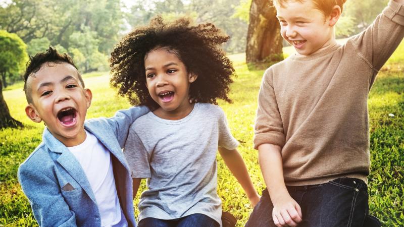 multi-racial kids in grassy field