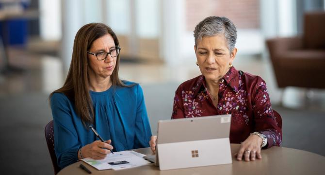 Photo of Dolores Acevedo-Garcia and Pamela Joshi working together at a tablet
